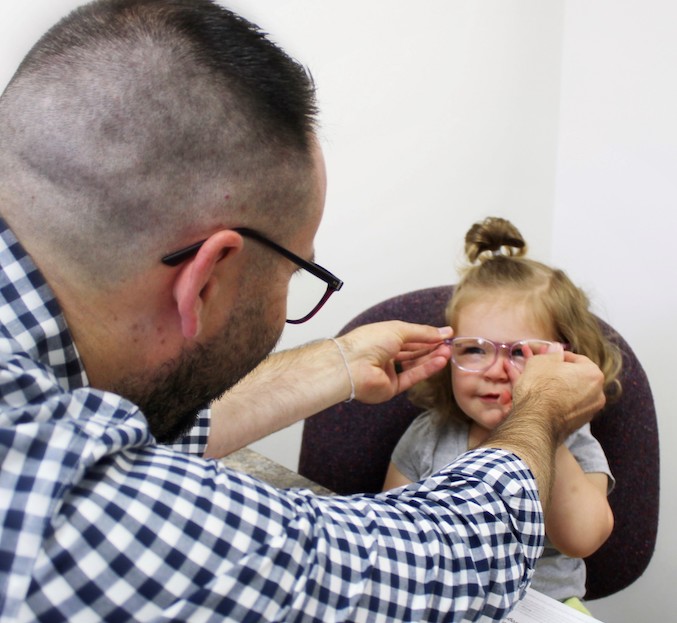 Little girl wearing glasses for the first time